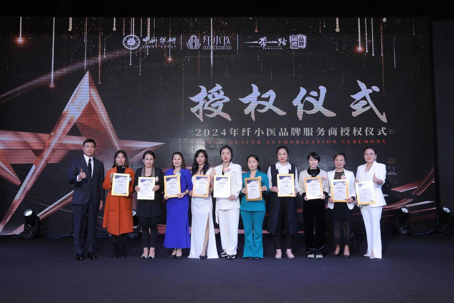 舞台标注2024年纤小医品牌服务商授权仪式的合影